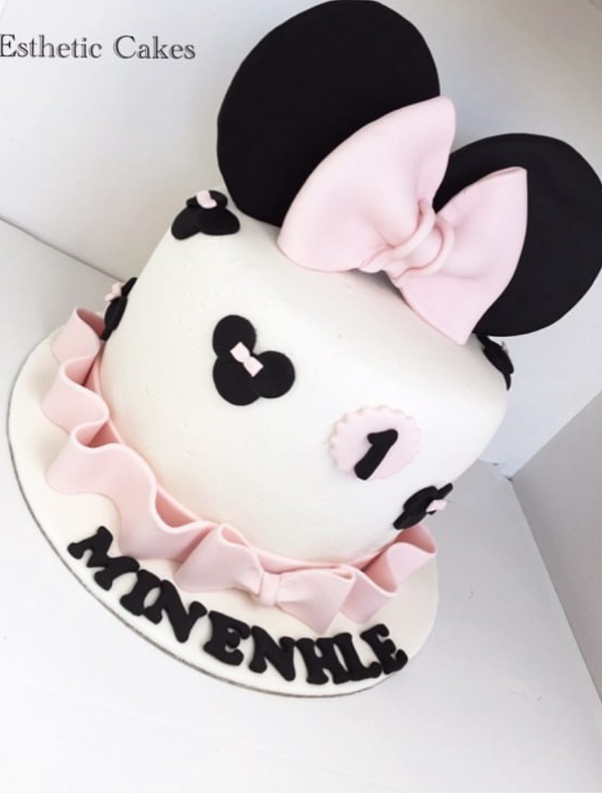 Two-tier pink Minnie Mouse birthday cake with pink bow