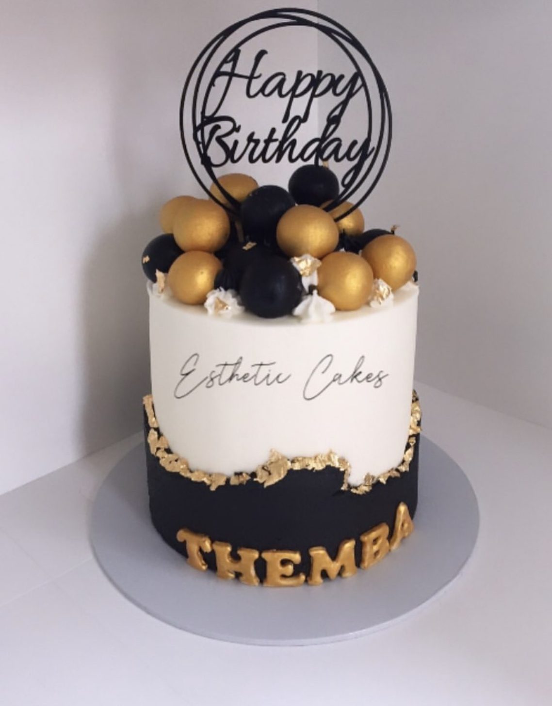 Gold and black birthday cake for Thembi with happy birthday topper