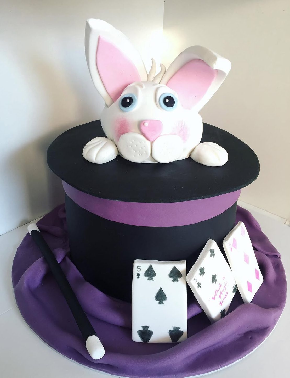 Sculpted magician top hat cake with sugar rabbit, wand and playing cards