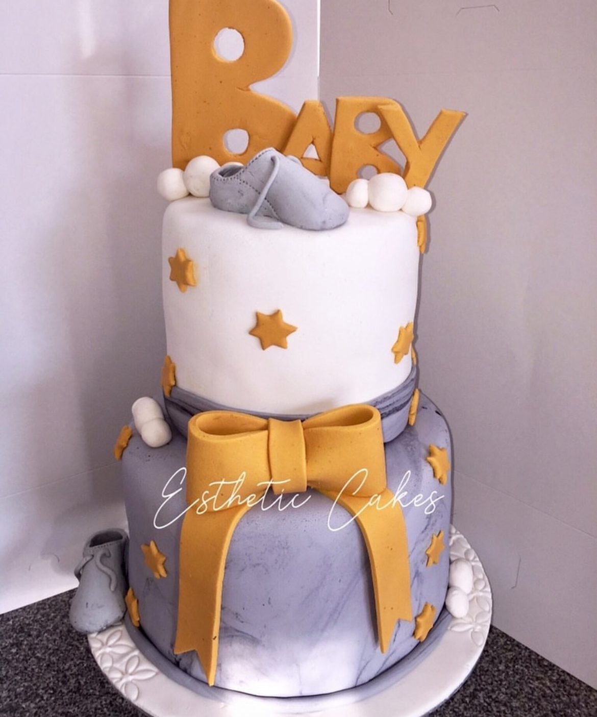 Two-tier grey and gold 'Baby' shower cake with bear detail