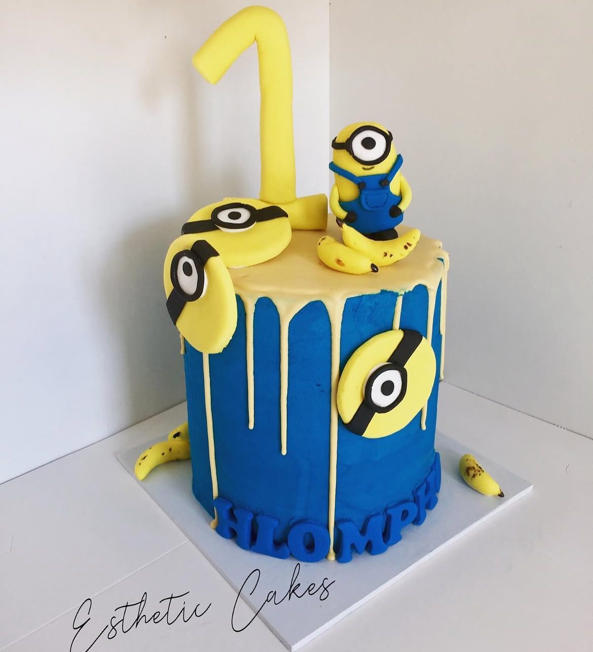 Minions-themed blue and yellow first birthday cake