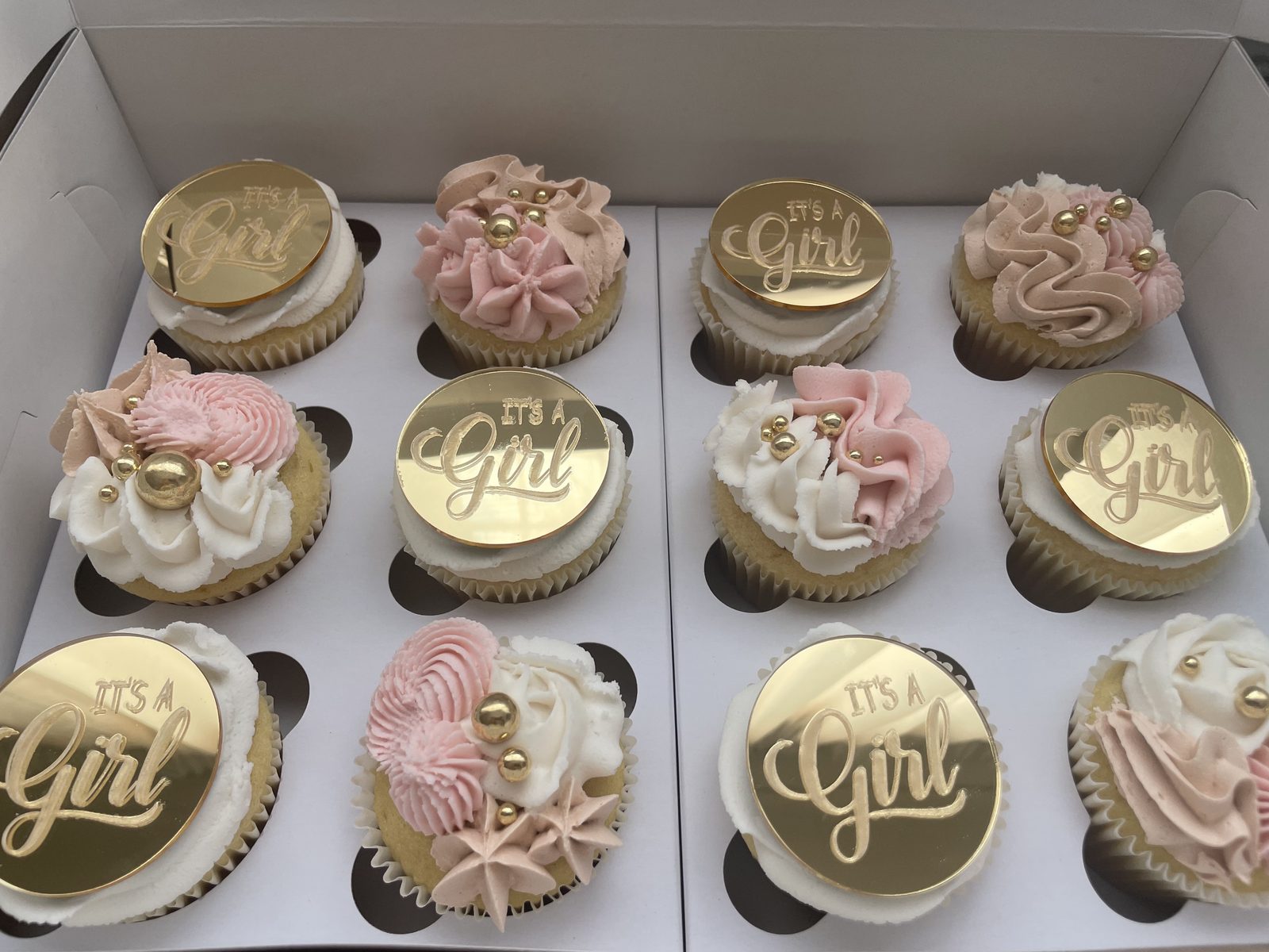 Boxed pink and gold cupcakes for a baby shower