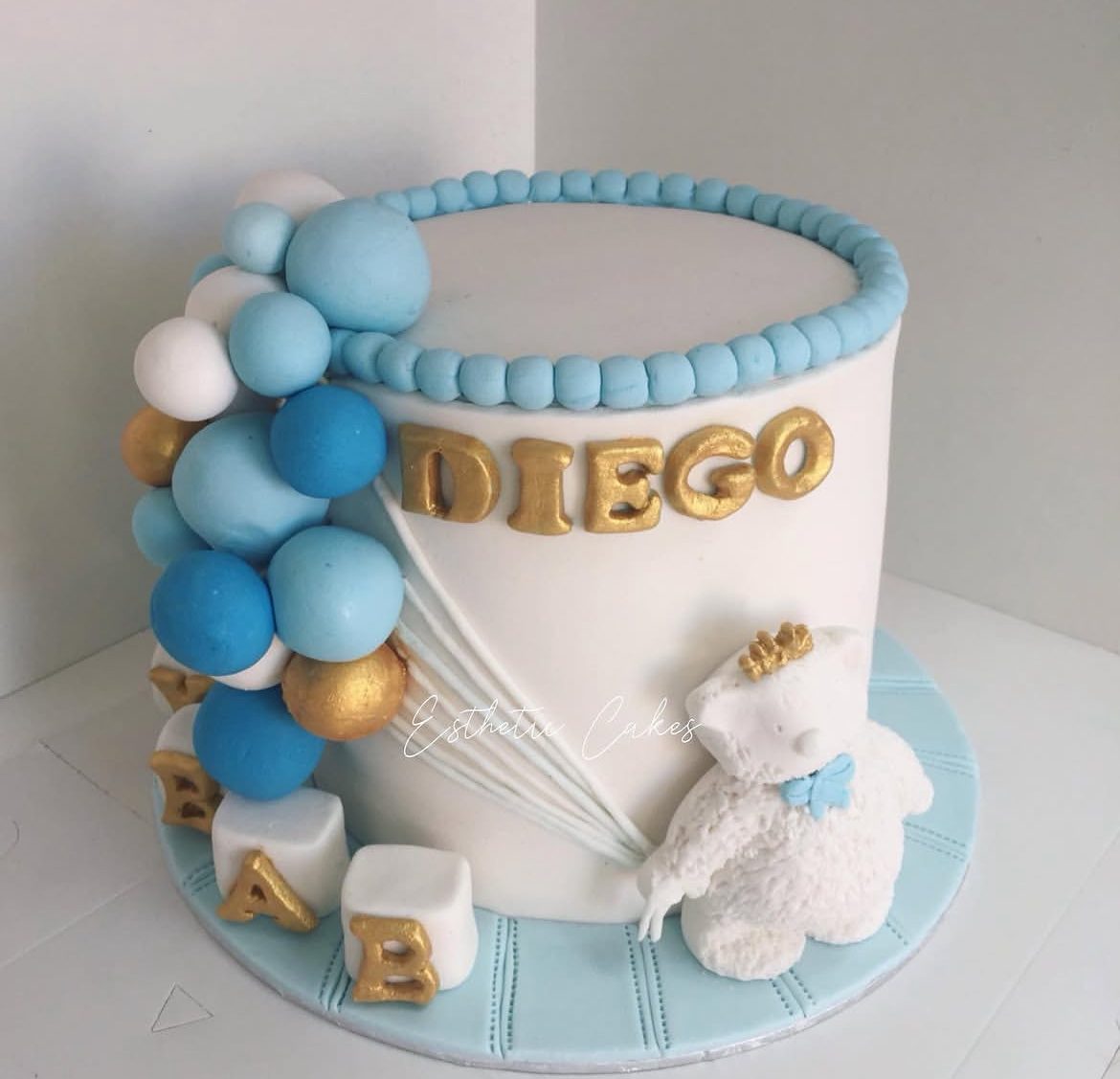 Blue and gold Diego birthday cake with balloon and teddy detail