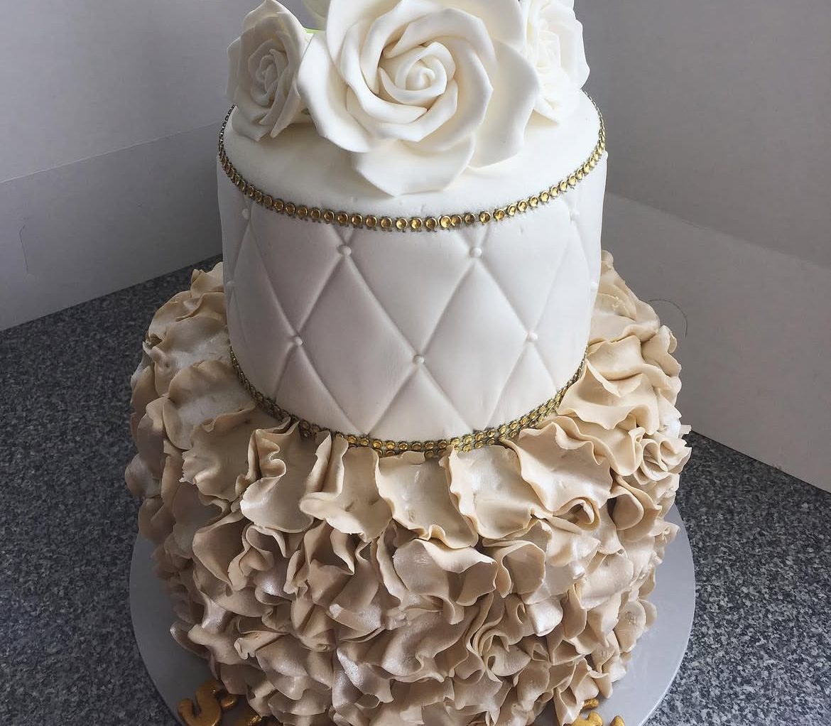 Two-tier white ruffle wedding cake with pearl topper
