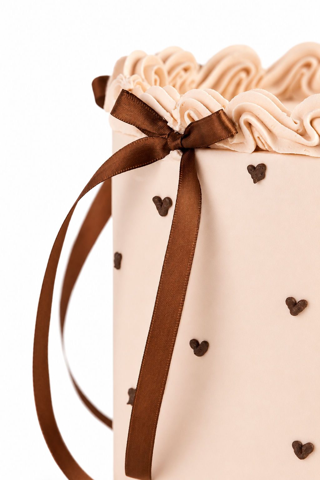 Nude buttercream cake with brown chocolate ribbon bow