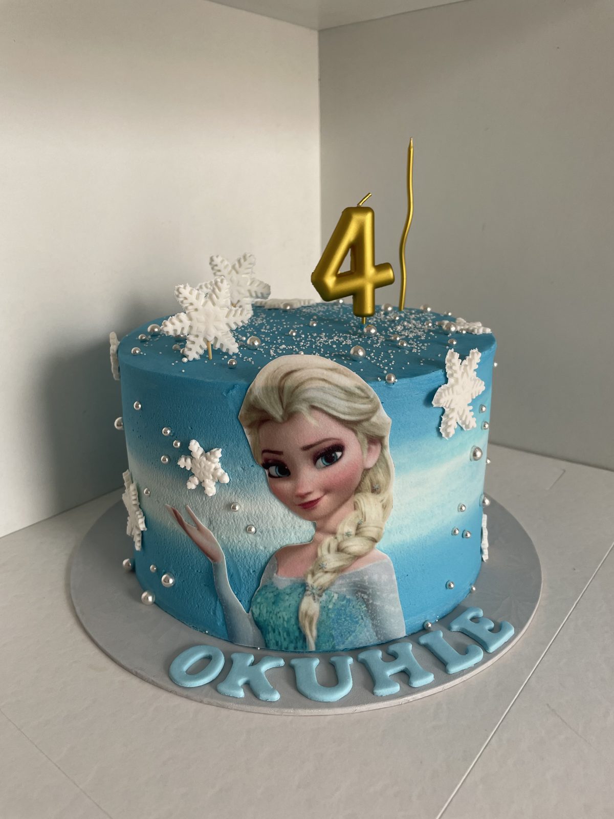 Frozen Elsa-themed 4th birthday cake in blue and white