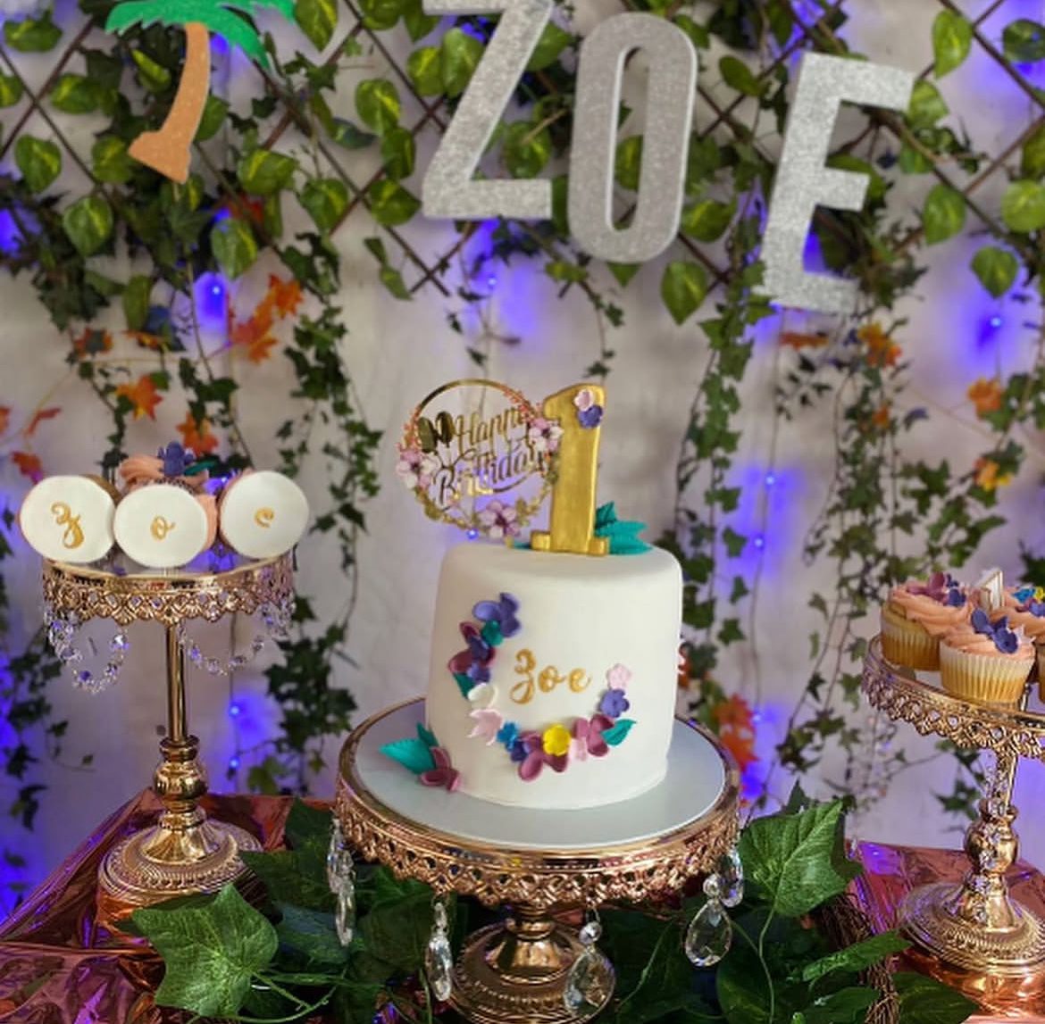 Zoe first birthday cake styled in a fairy light garden setup