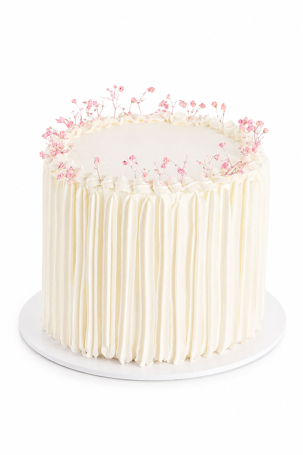 White vertical buttercream cake crowned with fresh pink baby's breath